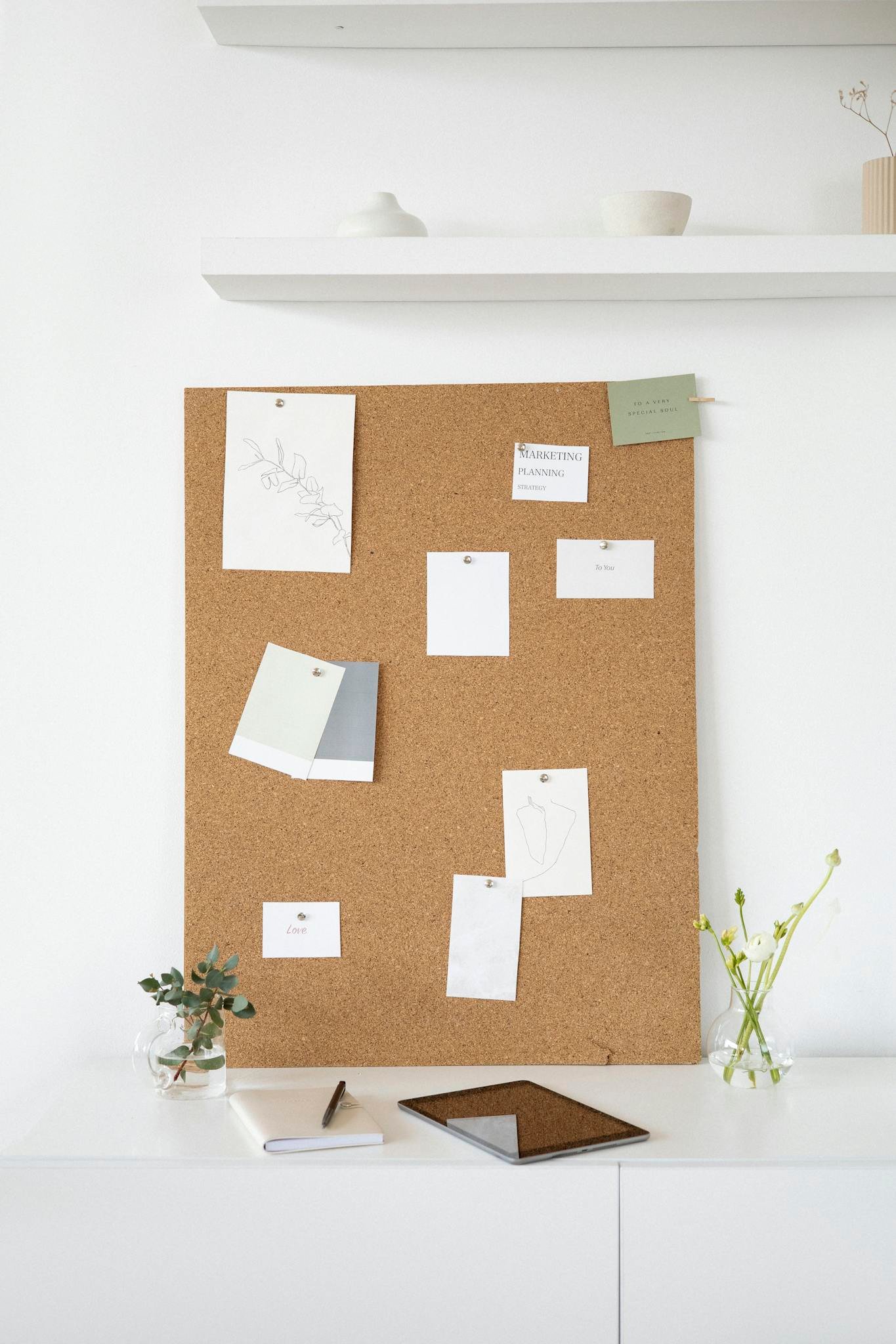 A clean and creative workspace featuring a cork board with notes, ideal for inspiration and design planning.