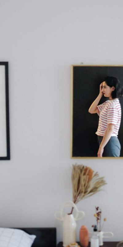 Stylish room interior featuring abstract art and a reflective mirror with a woman's portrait.